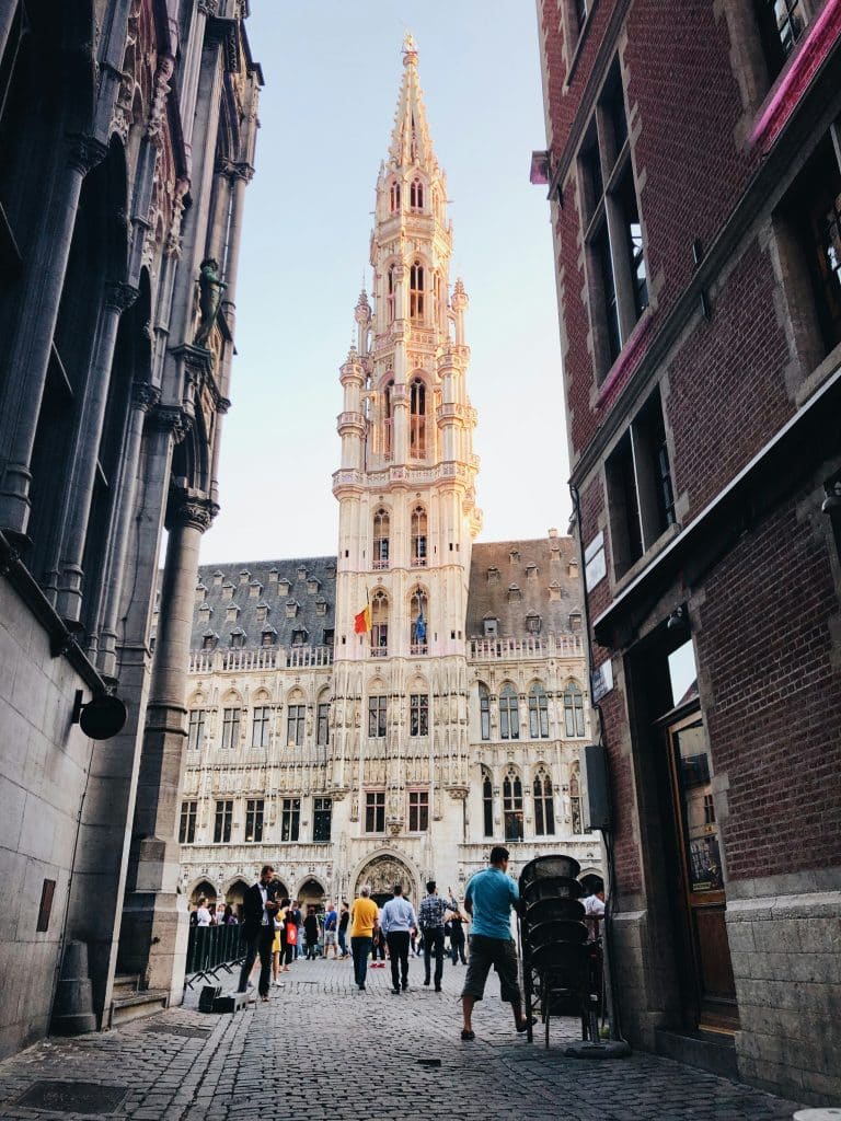 Photo of a tower on the Grand Place in Brussels, Belgium. The photo was taken in a narrow street between two buildings.