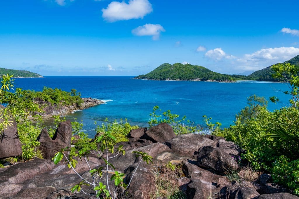 Photo of Mahé, a popular and well-known island in the Seychelles, surrounded by turquoise waters. The photo was taken from another island opposite.
