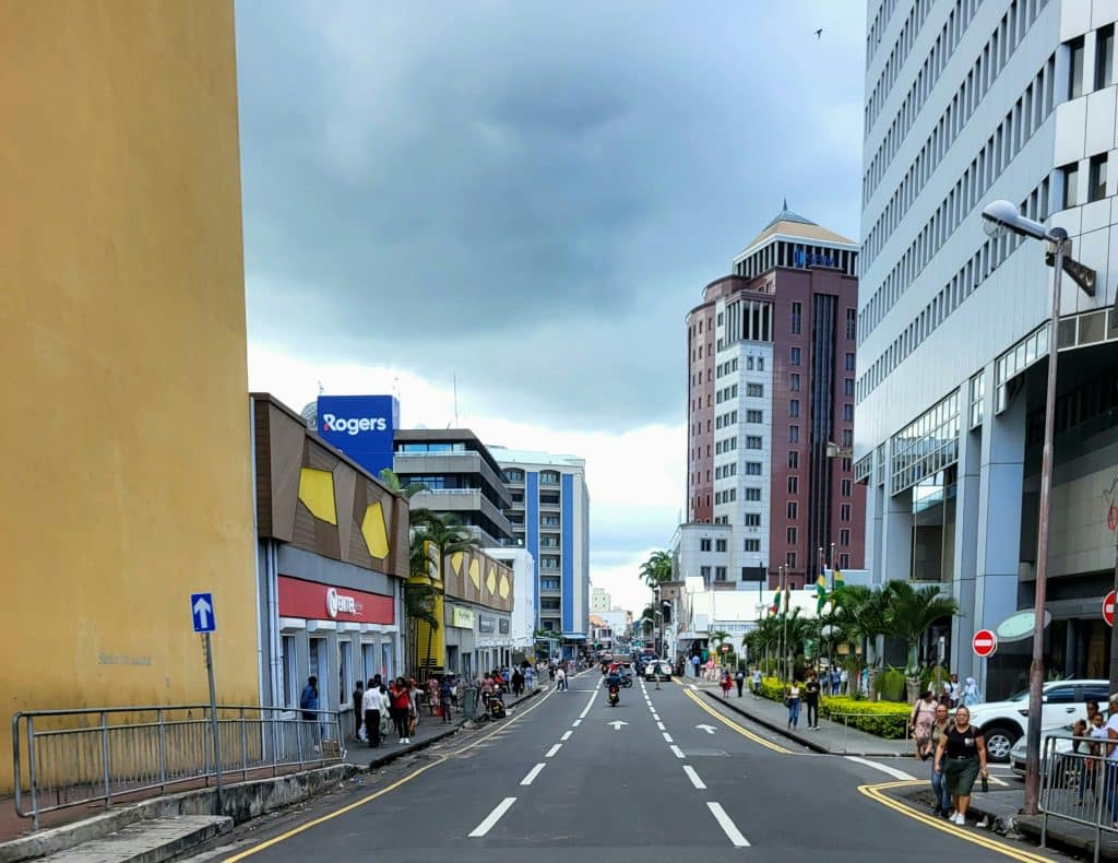 Street lined with tall buildings in the city of Port Louis on the island of Mauritius. The street is very busy and one-way for vehicles.