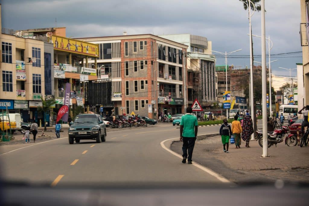 Photo of a street in Musanze, Rwanda, taken from the windscreen of a car driving down the street.