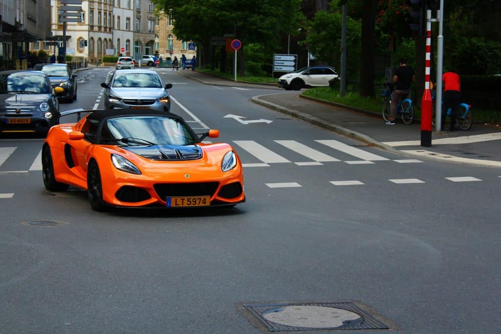 Luxury sports car in orange driving through the streets of Luxembourg.