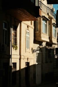 Facade of an old stone building illuminated by the sun in the old centre of Baku, Azerbaijan, with mouldings and frescoes.