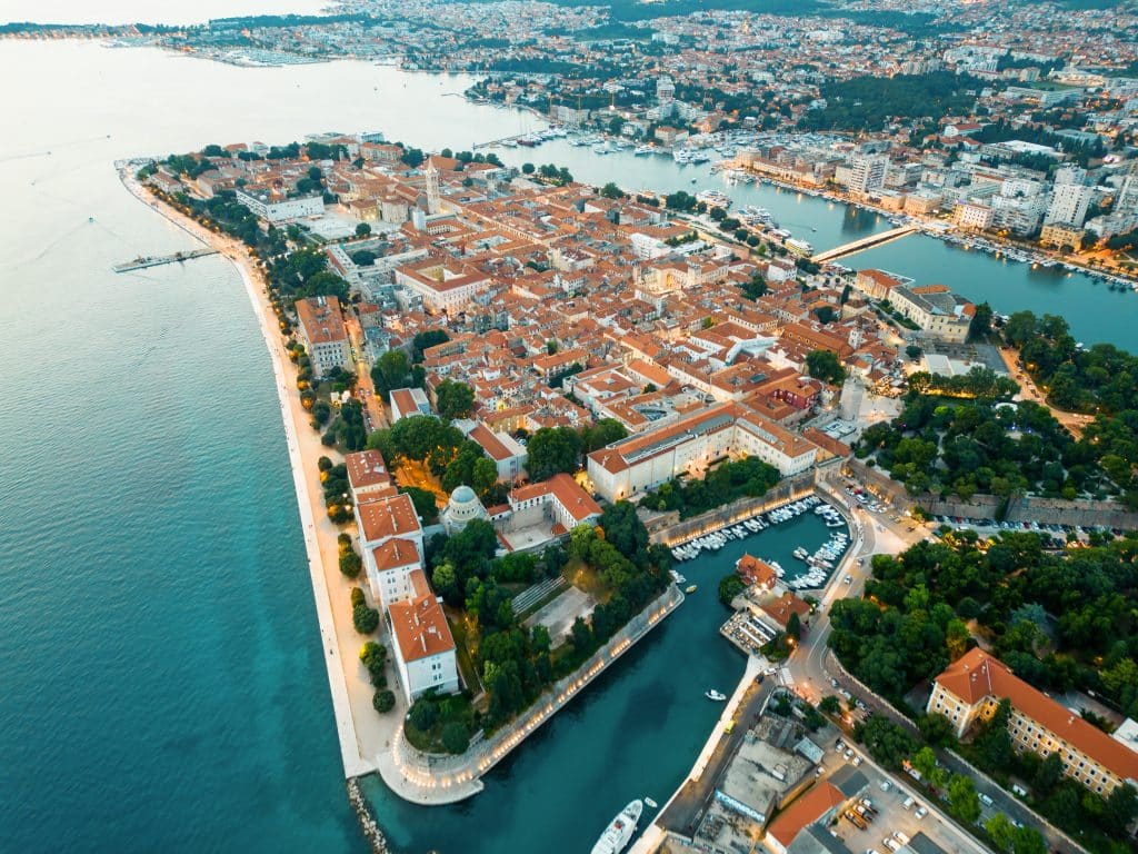 Aerial drone view of Zadar in evening, Croatia. Historical city centre with old buildings, narrow streets, water channels and Adriatic sea coast