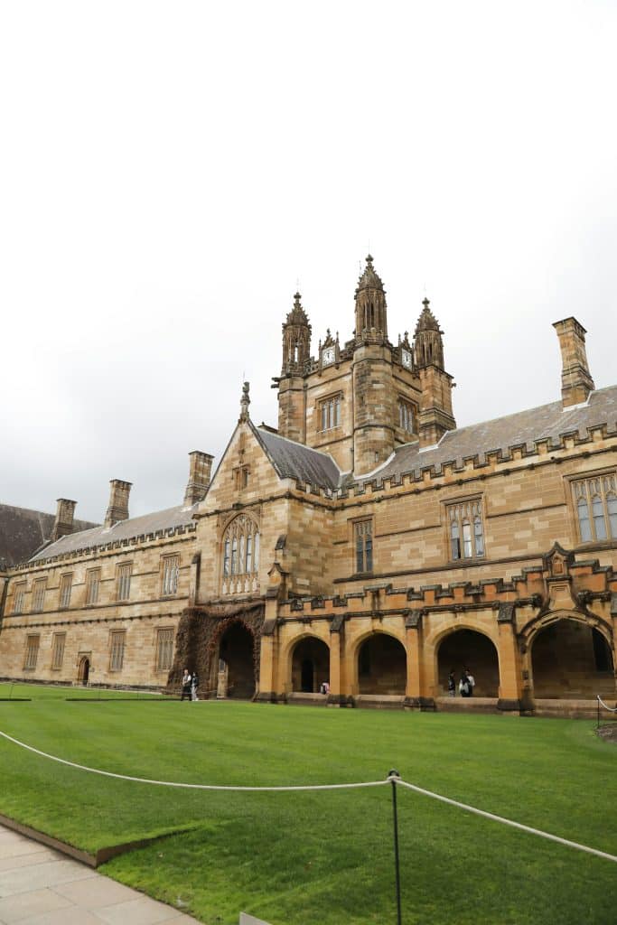facade of the University of Sydney and the surrounding green space.